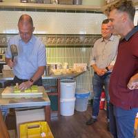 Landrat Ralf Hänsel stempelt Seifen unter den Blicken von Weinböhlas Bürgermeister Siegfried Zenker (hinten) und Dirk Schneider (rechts)